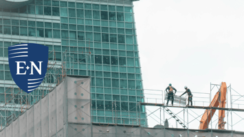 Two construction workers discussing holistic risk management. 